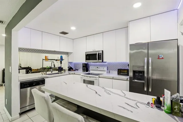 a kitchen with a sink a counter top space stainless steel appliances and cabinets