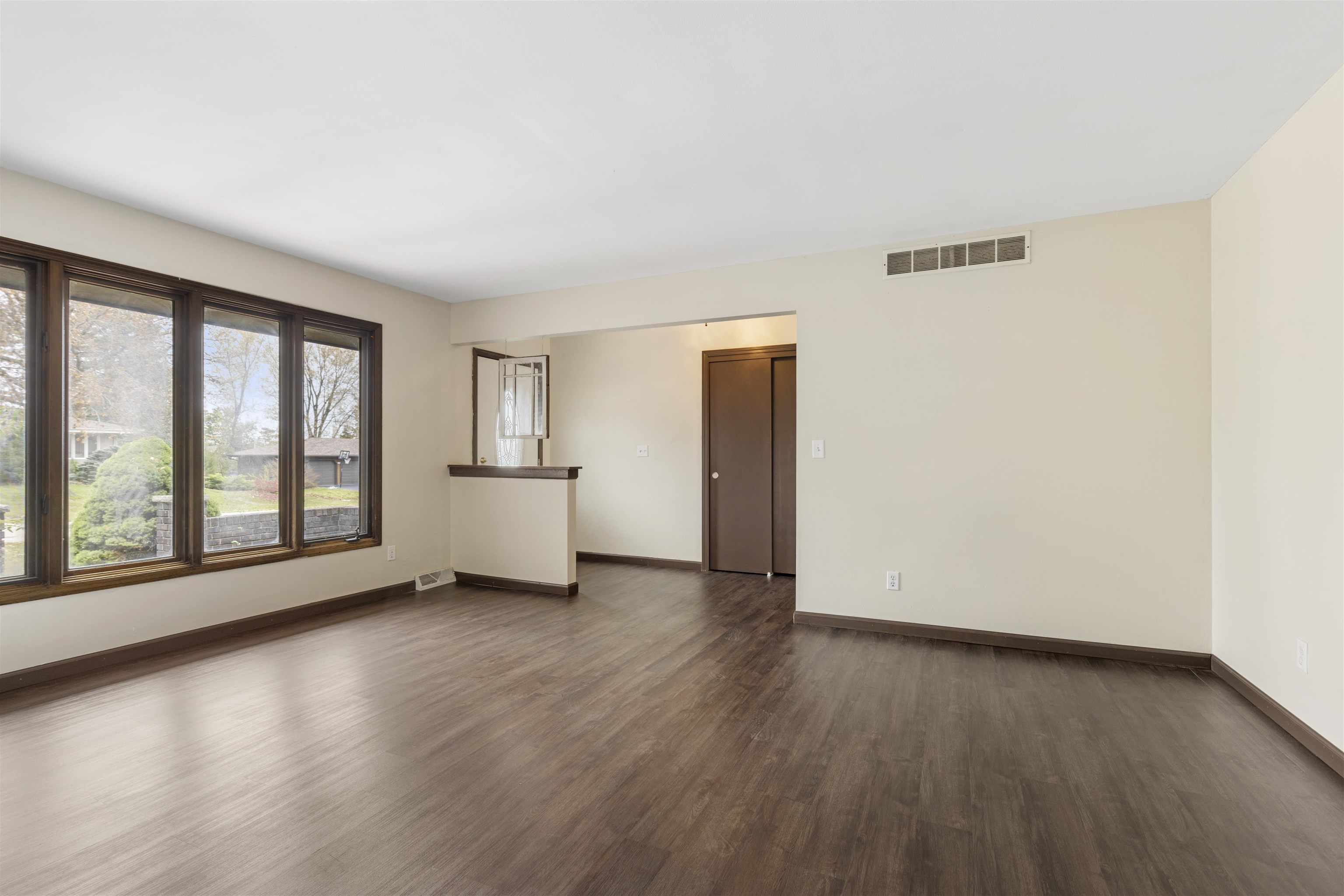 3428 Springwheat Street Rockford, IL 61114 - Photo 3 of 21 an empty room with wooden floor and windows