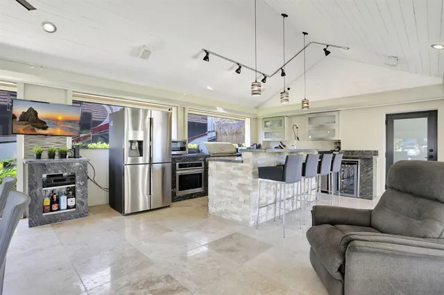 a large kitchen with stainless steel appliances kitchen island granite countertop a table and chairs