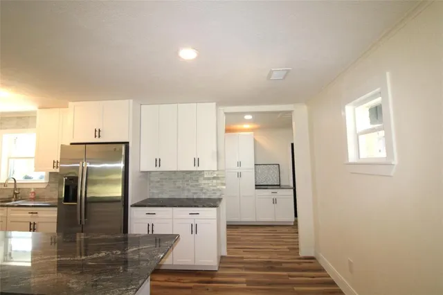 a kitchen with stainless steel appliances granite countertop a refrigerator and a stove
