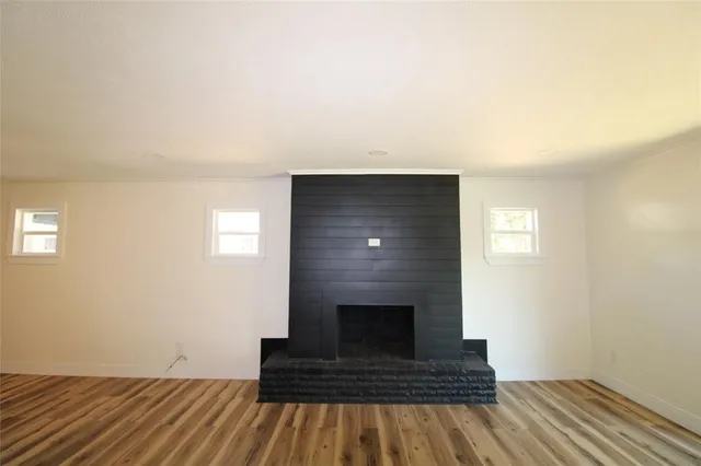 a living room with a fireplace and wooden floor