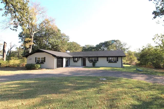 a front view of a house with a yard and trees