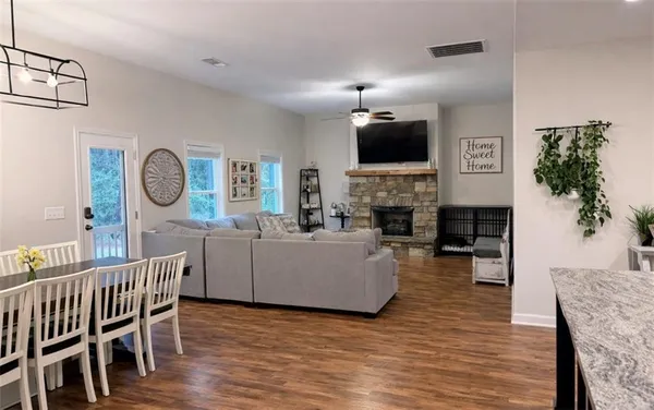 a living room with furniture a fireplace a flat screen tv and potted plant