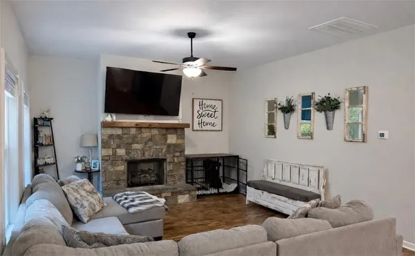a living room with furniture a fireplace and a flat screen tv