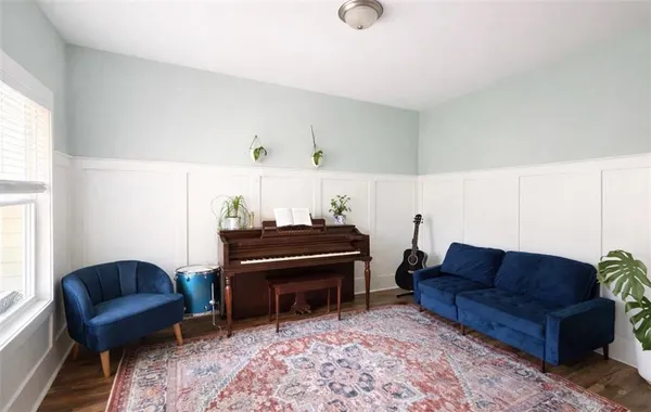 a living room with furniture a piano and a window