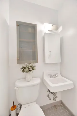 a bathroom with a sink toilet and mirror