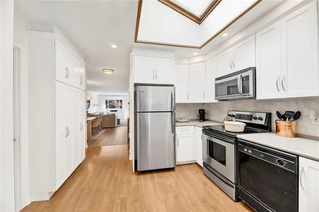 a kitchen with a refrigerator cabinets and wooden floor