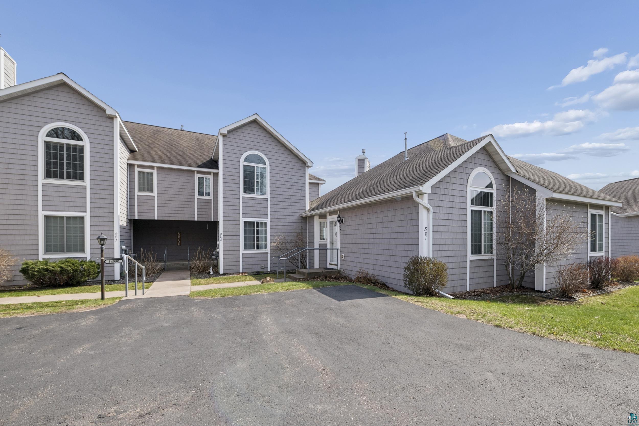 34590 Bay View Road, Unit 801 Bayfield, WI 54814 - Photo 36 of 36 Multi-unit property featuring gray shingle siding, arched windows, and a paved parking area