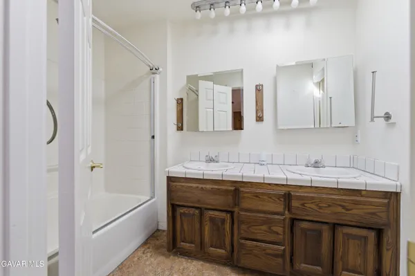 a bathroom with a tub sink and mirror