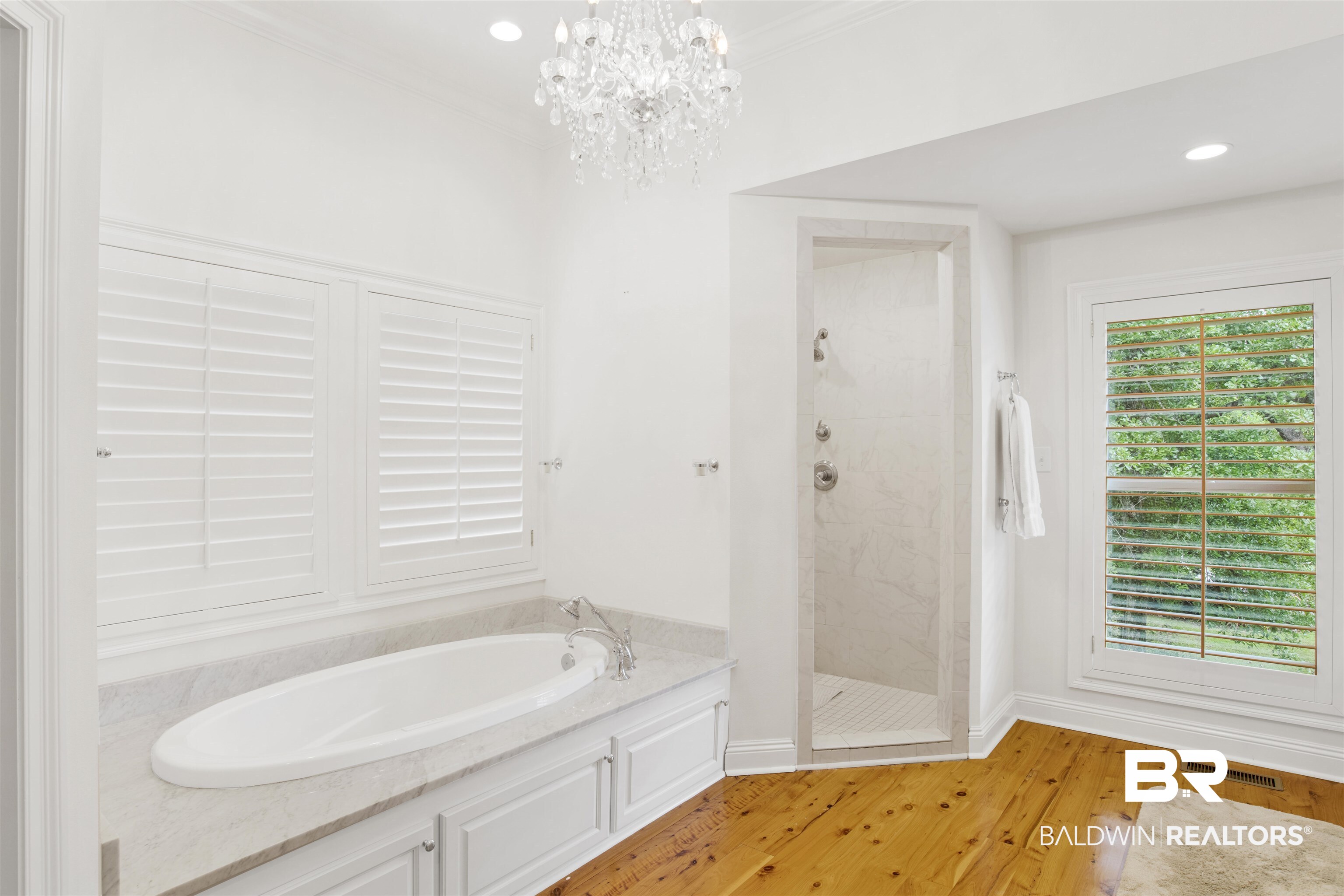 16864 Ferry Rd Circle Fairhope, AL 36532 - Photo 46 of 68 Bathroom featuring a garden tub, tiled shower, wood finished floors, a chandelier, and baseboards