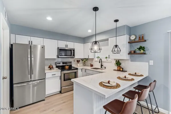a kitchen with refrigerator cabinets and wooden floor