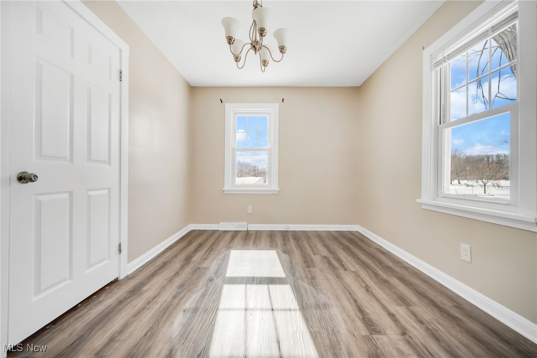 5674 Middle Ridge Road Madison, OH 44057 - Photo 15 of 26 Formal dining room with wood-style flooring and an inviting chandelier