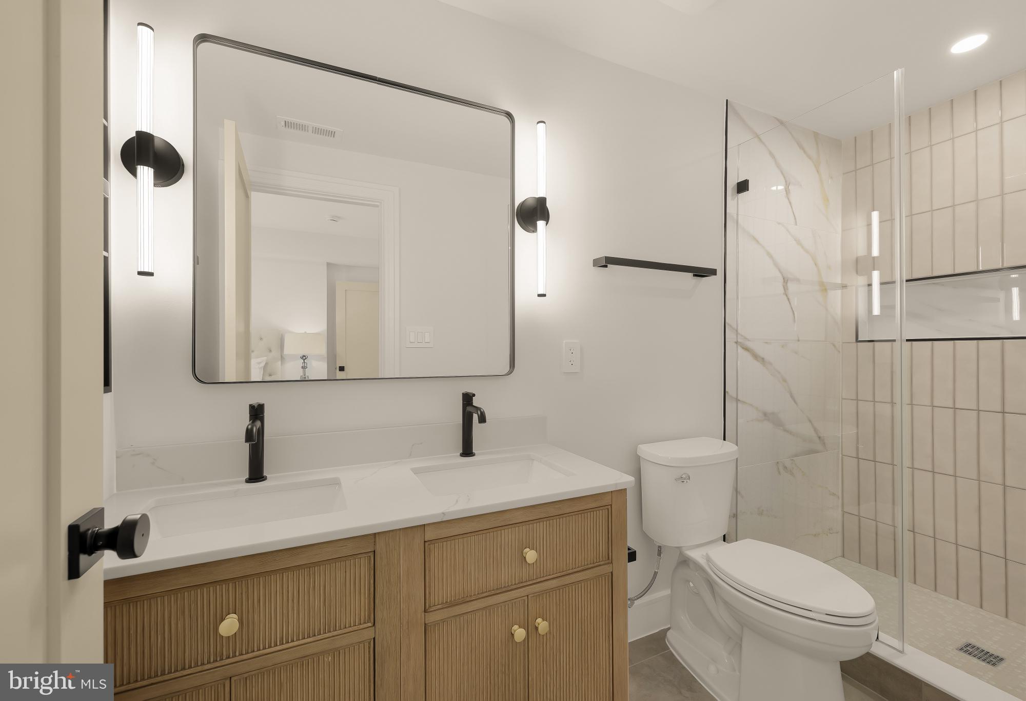 1463 Harvard Street Northwest, Unit 2 Washington, DC 20009 - Photo 22 of 25 a bathroom with a toilet sink a mirror and shower