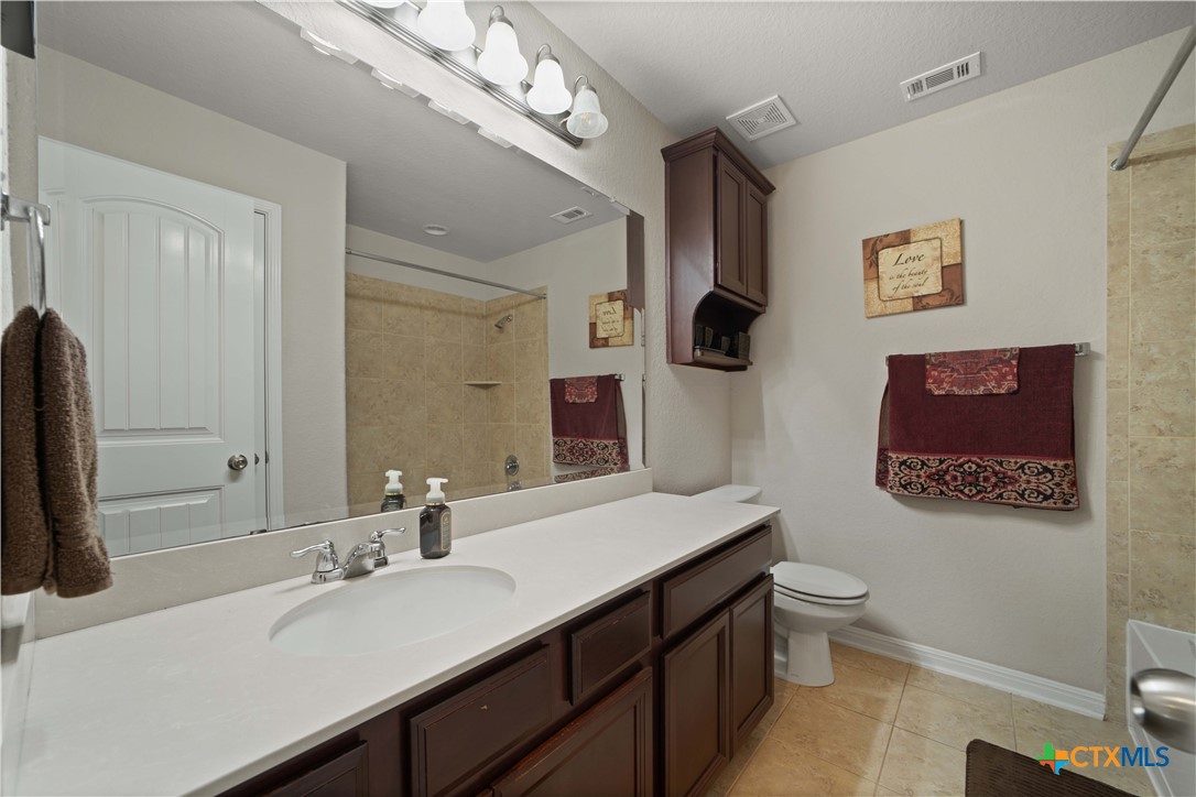 232 Albarella Cibolo, TX 78108 - Photo 33 of 42 a bathroom with a granite countertop sink a large mirror a toilet and a bathtub