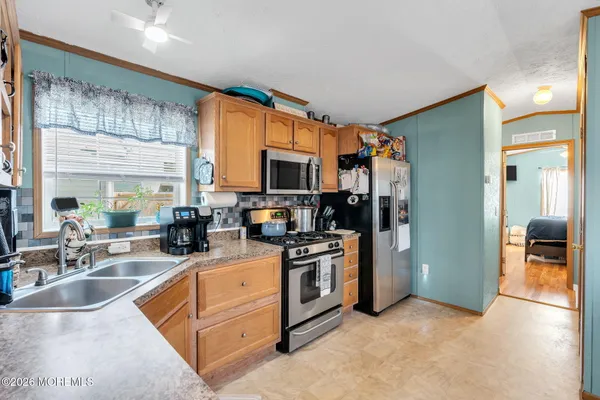 a kitchen with stainless steel appliances granite countertop a sink a stove and a refrigerator