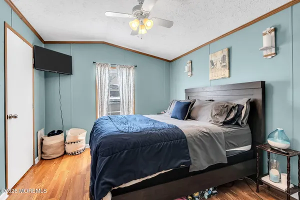 a bedroom with a bed and wooden floor