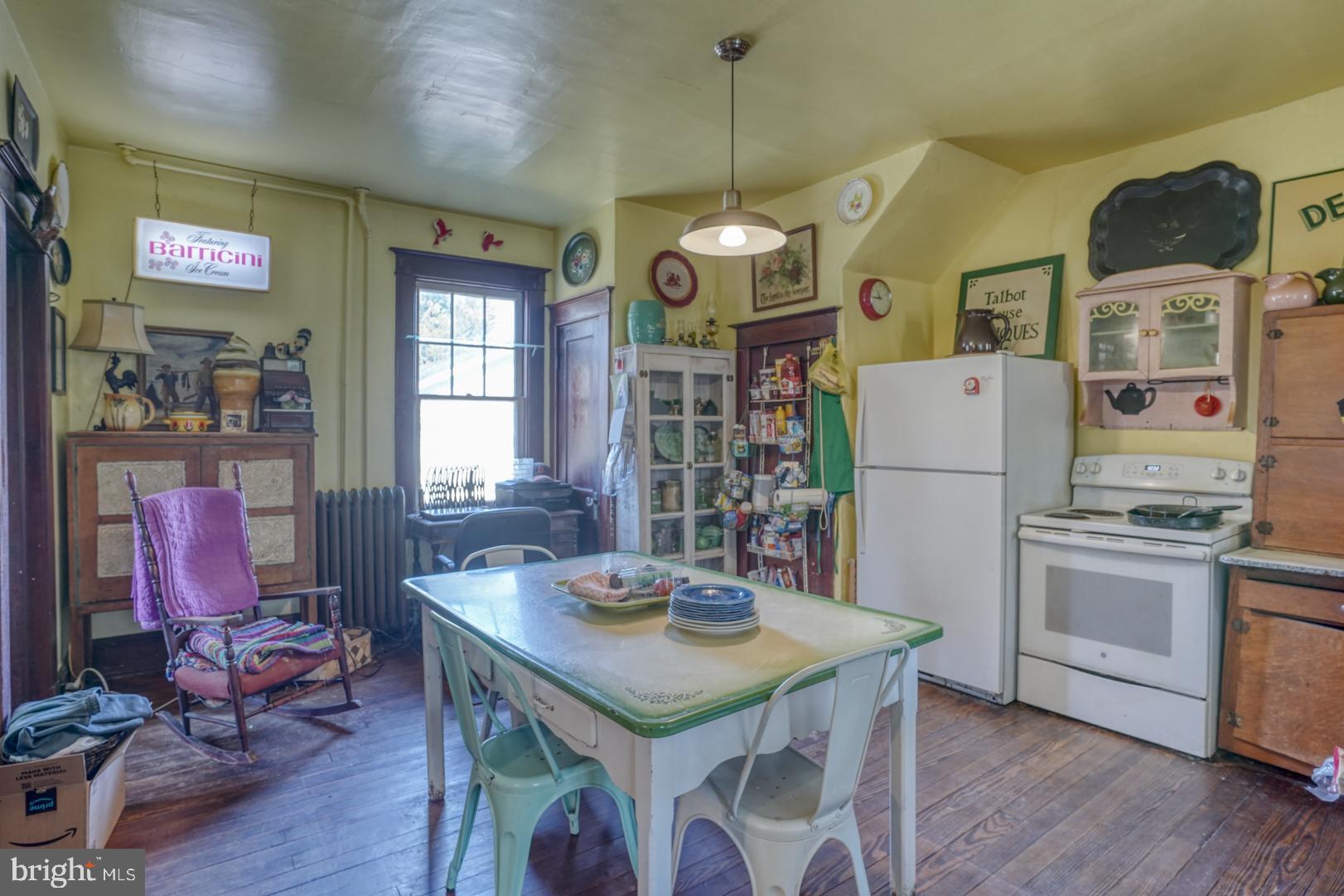 4096 Main Street Trappe, MD 21673 - Photo 33 of 70 a open kitchen with stainless steel appliances granite countertop a stove a refrigerator a oven a dining table and chairs with wooden floor