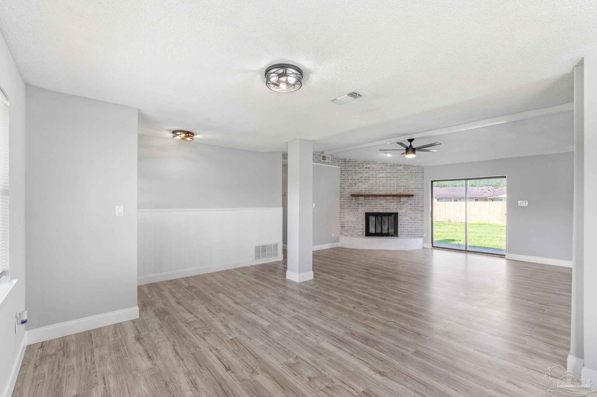 2501 Argle Road Cantonment, FL 32533 - Photo 15 of 36 an empty room with wooden floor and fireplace