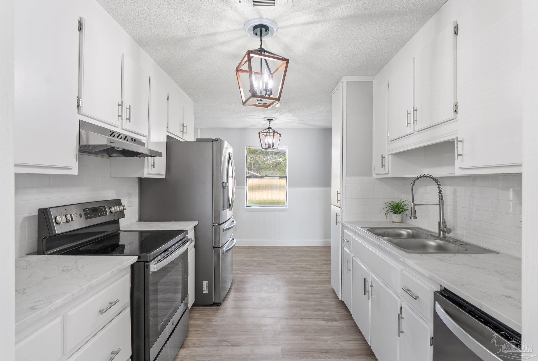 2501 Argle Road Cantonment, FL 32533 - Photo 3 of 36 a kitchen with stainless steel appliances a sink stove and refrigerator