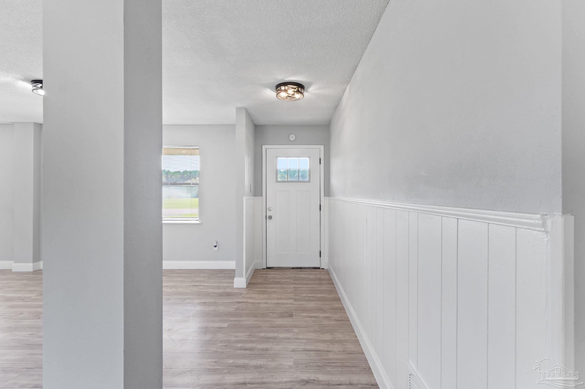 2501 Argle Road Cantonment, FL 32533 - Photo 10 of 36 a view of a hallway with wooden floor and a bathroom