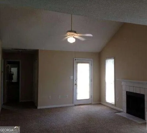 an empty room with ceiling fan and window