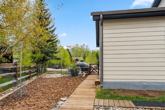a view of a patio with table and chairs with wooden fence and plants