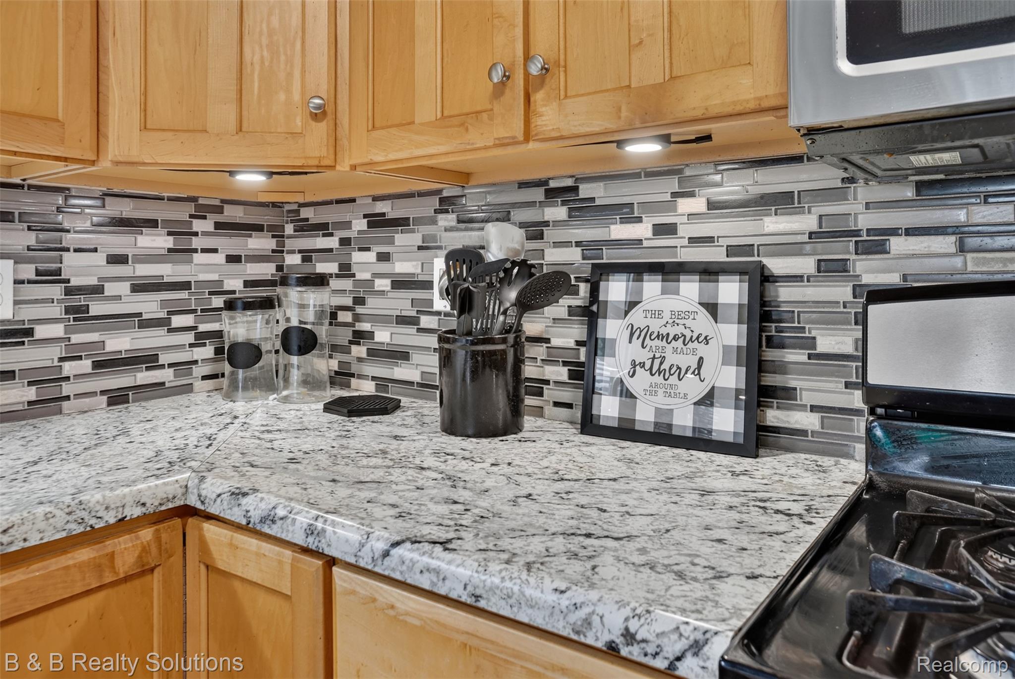 3097 East Burnside Road North Branch, MI 48461 - Photo 12 of 52 Kitchen counter space featuring light-toned cabinetry, a mosaic tile backsplash, and a gas range