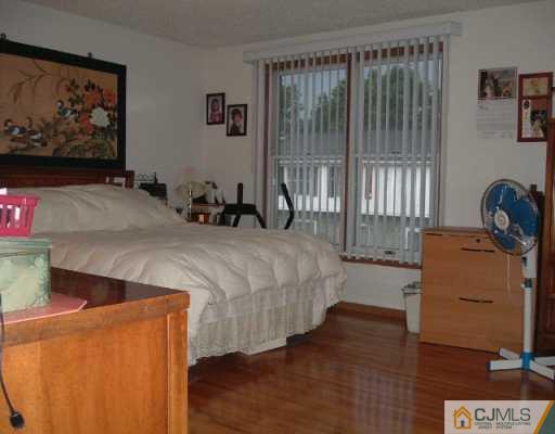 4701 Hana Road Edison, NJ 08817 - Photo 5 of 8 a bedroom with a bed and a dresser next to a window