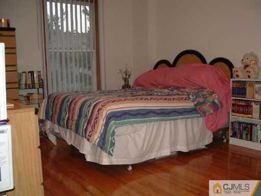 4701 Hana Road Edison, NJ 08817 - Photo 6 of 8 a bed sitting in a bedroom next to a window