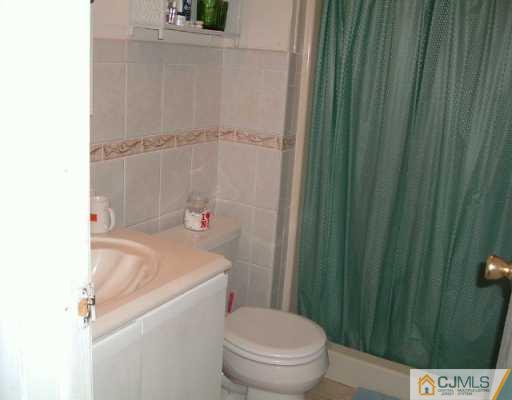 4701 Hana Road Edison, NJ 08817 - Photo 7 of 8 a white toilet sitting next to a shower curtain