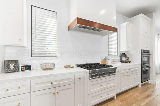 a kitchen with stainless steel appliances cabinets and a window