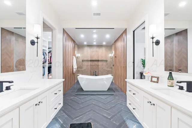 a spacious bathroom with a double vanity sink mirror and bathtub