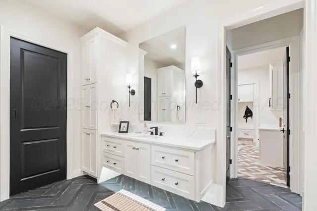 a spacious bathroom with a double vanity sink a mirror and a shower