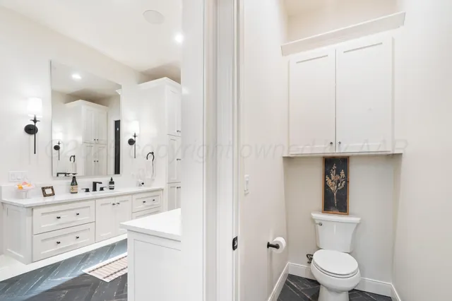 a bathroom with a toilet sink and mirror