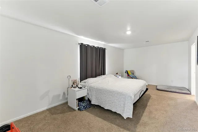 a spacious bedroom with a bed and a table