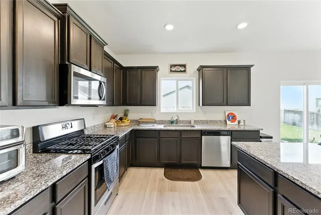 a kitchen with stainless steel appliances granite countertop a sink stove and refrigerator
