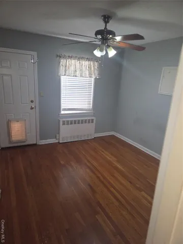 a view of an empty room with a chandelier fan
