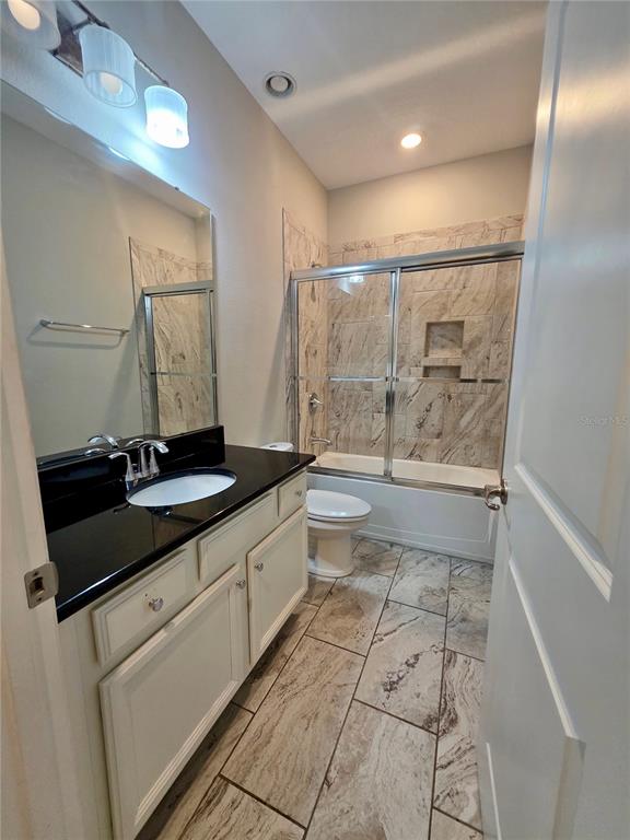 8582 Powder Ridge Trail Windermere, FL 34786 - Photo 25 of 50 a bathroom with a granite countertop sink a toilet a mirror and shower