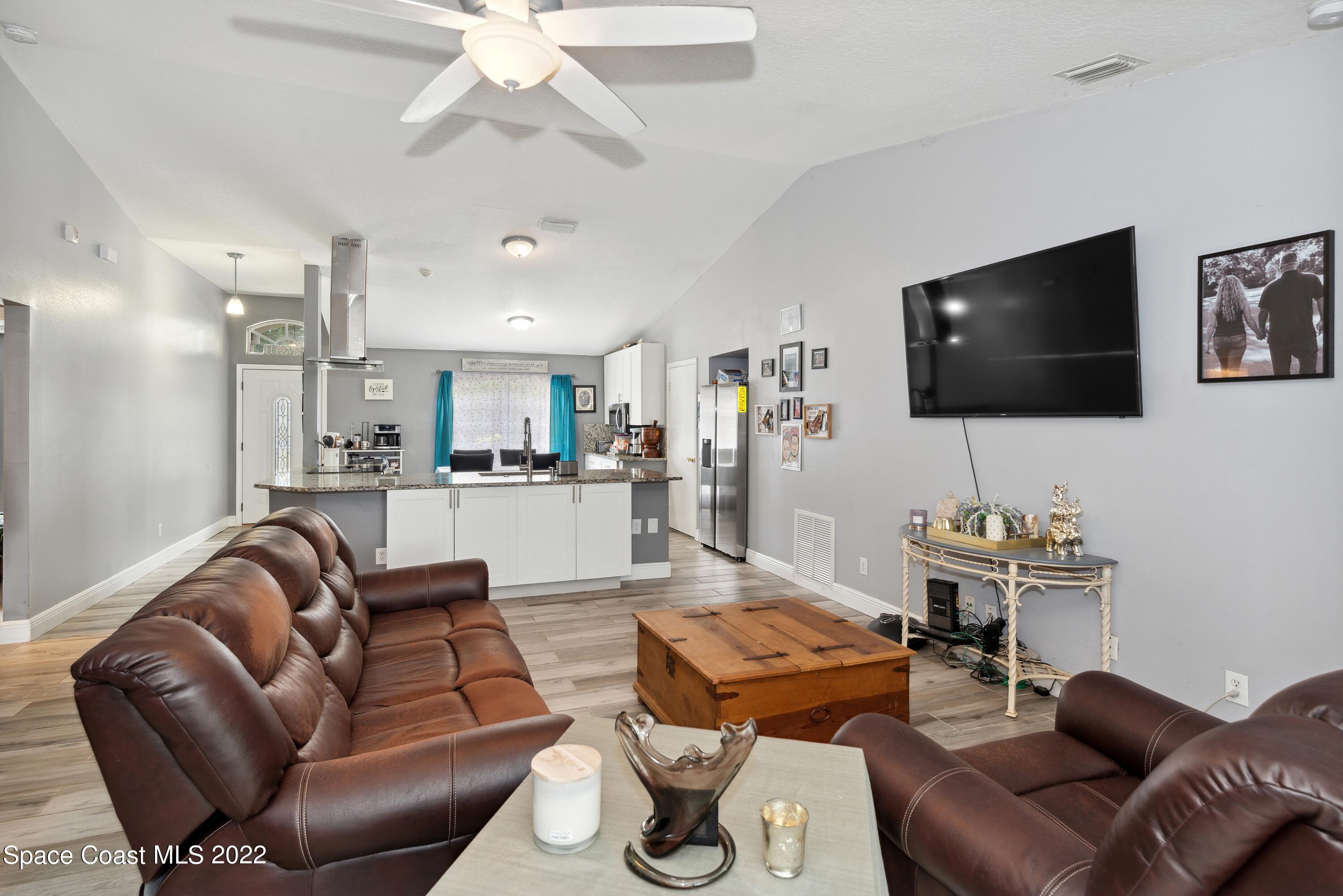 816 Tedder Road Southeast Palm Bay, FL 32909 - Photo 8 of 18 07_816TedderRd_94_FamilyRoomKitchen_HiRe