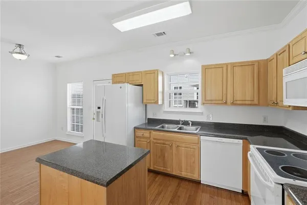 a kitchen that has a sink a stove counter top space and cabinets
