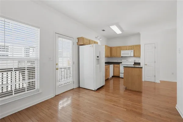 a view of kitchen with wooden floor and electronic appliances
