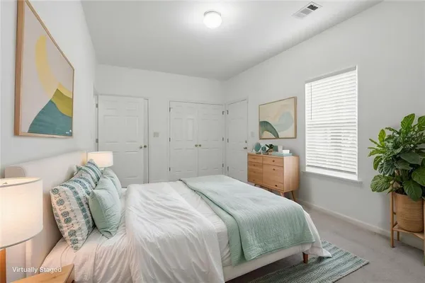 a bedroom with a bed and a potted plant