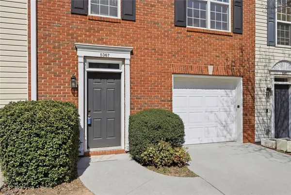 a front view of a house with a garden and plants