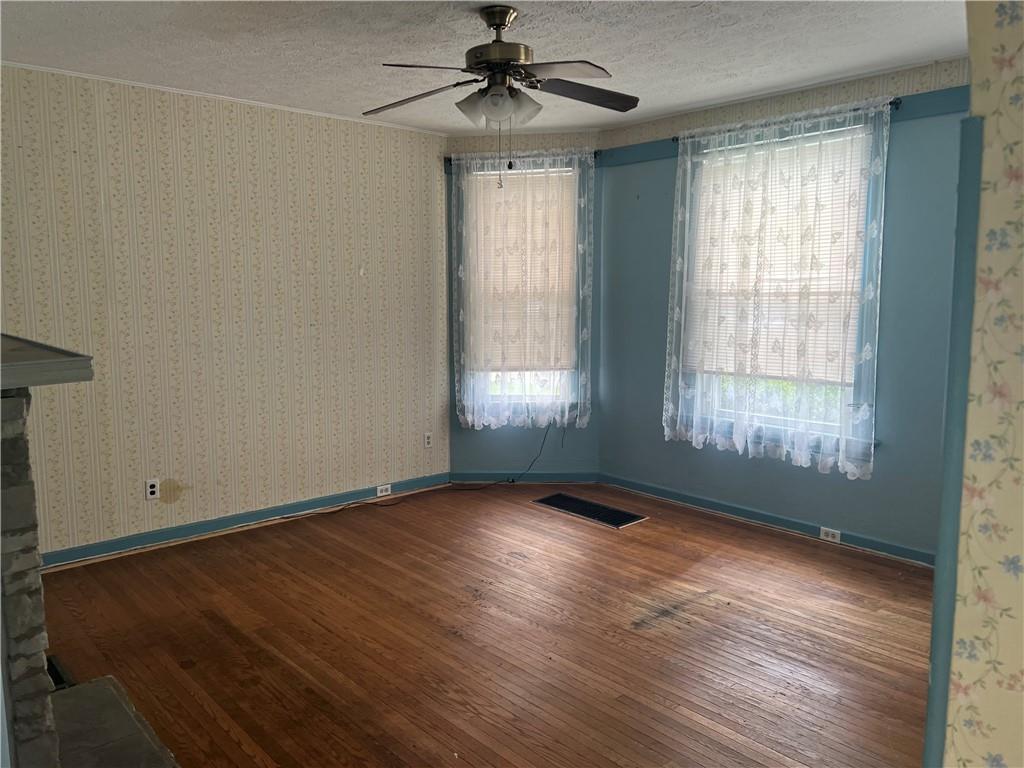 802 4th Street Rochester, PA 15074 - Photo 6 of 31 an empty room with wooden floor chandelier fan and windows