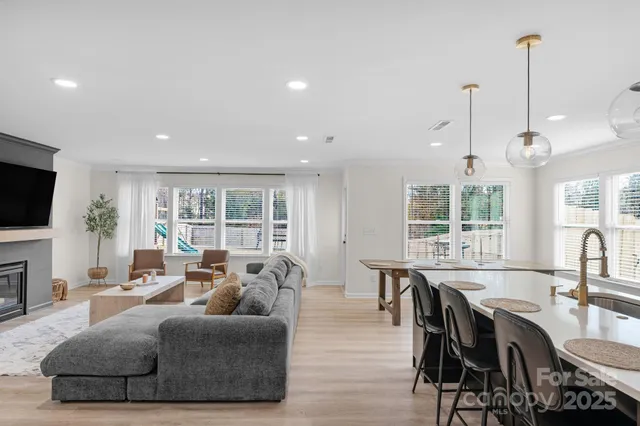 a living room with furniture a flat screen tv and a large window