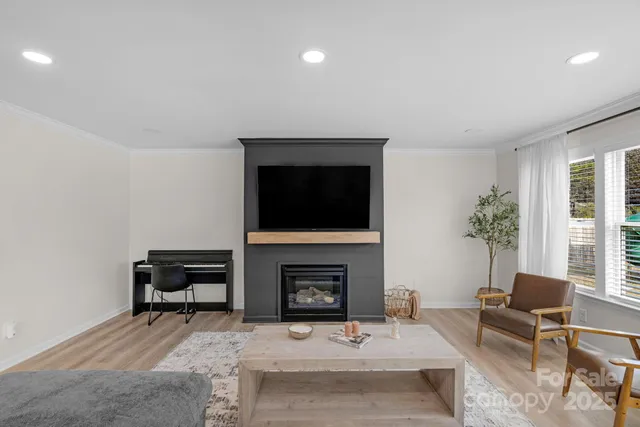 a living room with furniture a flat screen tv and a fireplace