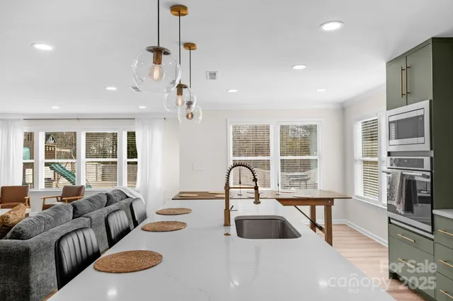 a living room with furniture a large window and a chandelier