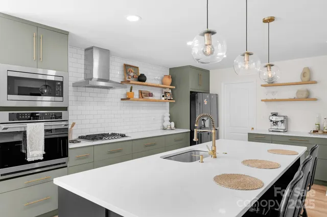 a kitchen with kitchen island a sink stove and microwave