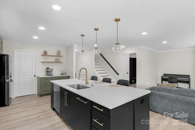 a kitchen with a sink a counter top space stainless steel appliances and a center island