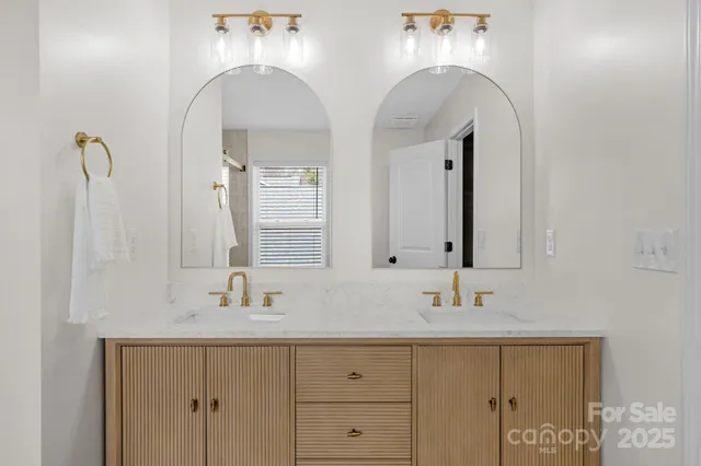 a bathroom with double vanity sinks and two mirror